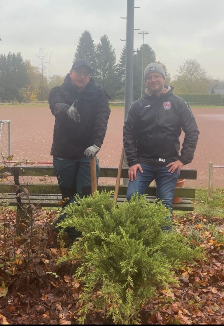 Baumpflanzchallenge Keldenich Zwei Personen stehen vor einer Pflanze, lächeln und halten Gärtenwerkzeuge.